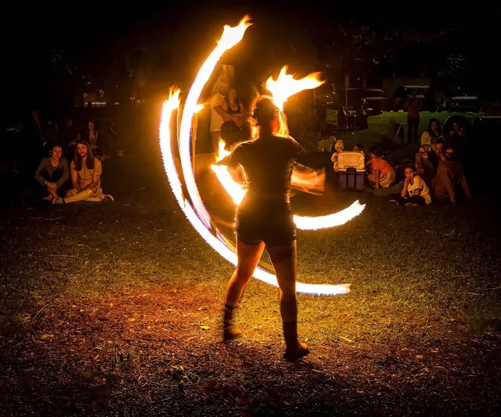 fire performer creates curved trails of flame