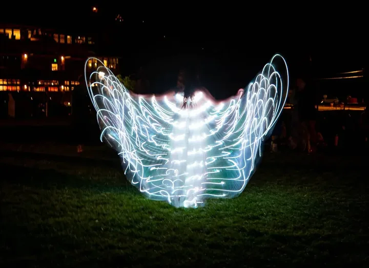 a woman walks away with wings of light