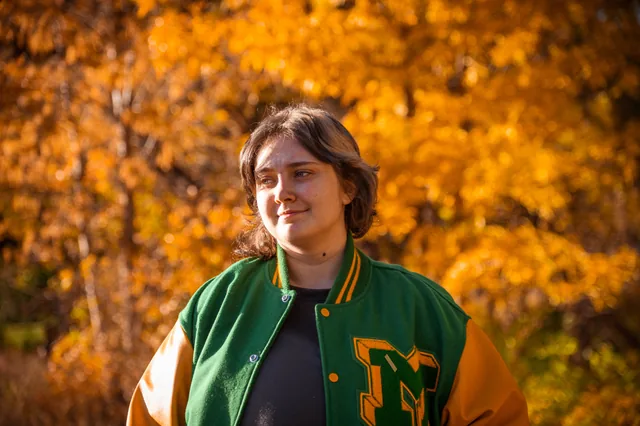 Backlit autumn portrait in a varsity jacket